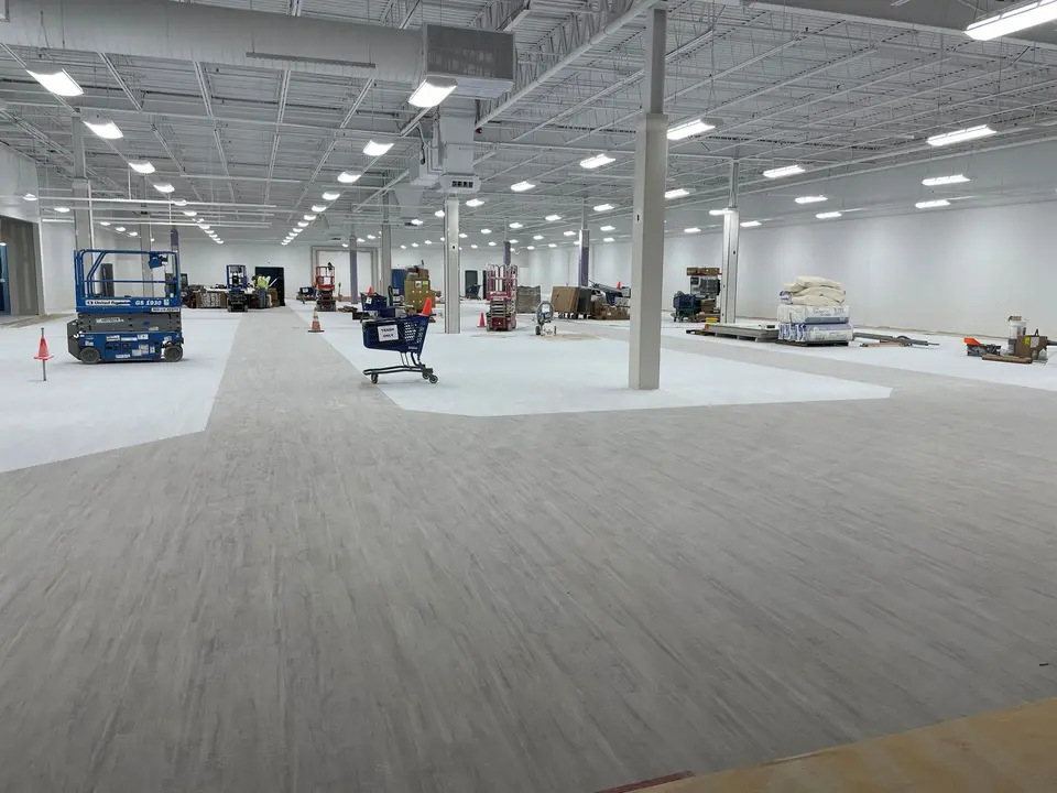 Grey LVT planks laid across a large retail floor at TJ Maxx, Salem NH